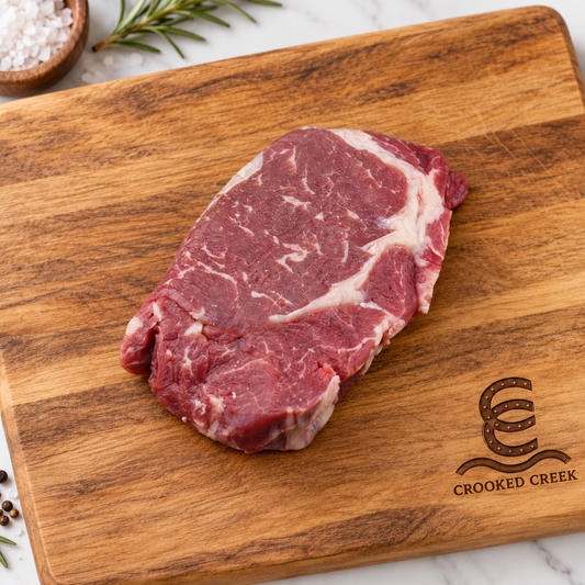Crooked Creek Akaushi chuck eye steak on a branded wooden cutting board